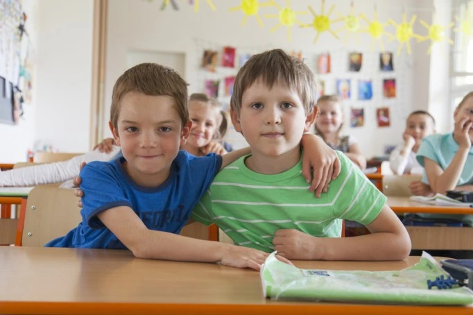 Two classmates sharing a warm embrace, fostering social connections and friendship