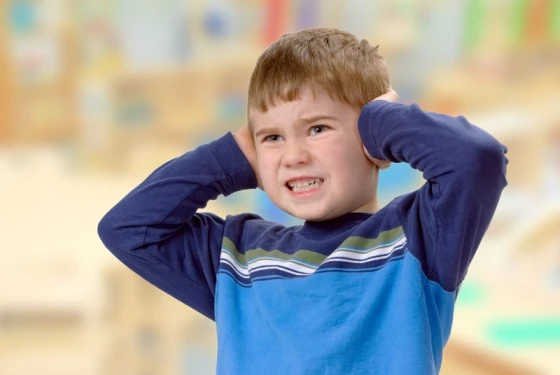 Child with Sensory Processing Disorder covering ears to manage sensory stimuli