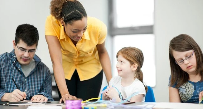 A teacher attentively looks after a student during a school activity, ensuring a smooth transition.