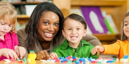 Image of a teacher providing individualized support to a child with special needs in the classroom