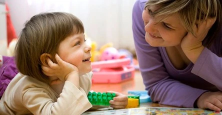 Image of a mom joyfully playing with her baby, exemplifying the benefits of early intervention