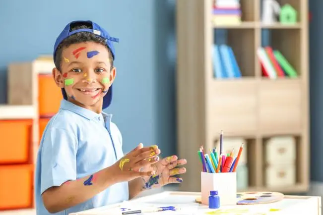 A child engaged in an art therapy session, painting on a canvas with a brush, exploring emotions and expressing themselves artistically.