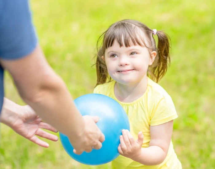 A child with Down Syndrome joyfully playing and exploring, showcasing their enthusiasm and creativity.