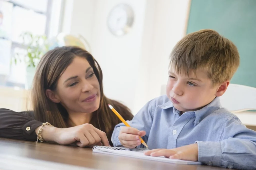 Teacher providing assistance to a student, showcasing the value of personalized support through the Individualized Education Plan (IEP).