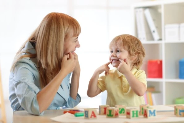 A therapist interacting with a child during a language therapy session